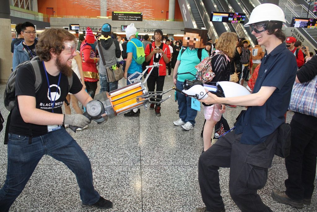 Cosplayers holding replica Gravity Gun and Portal Gun props at Otakuthon 2014