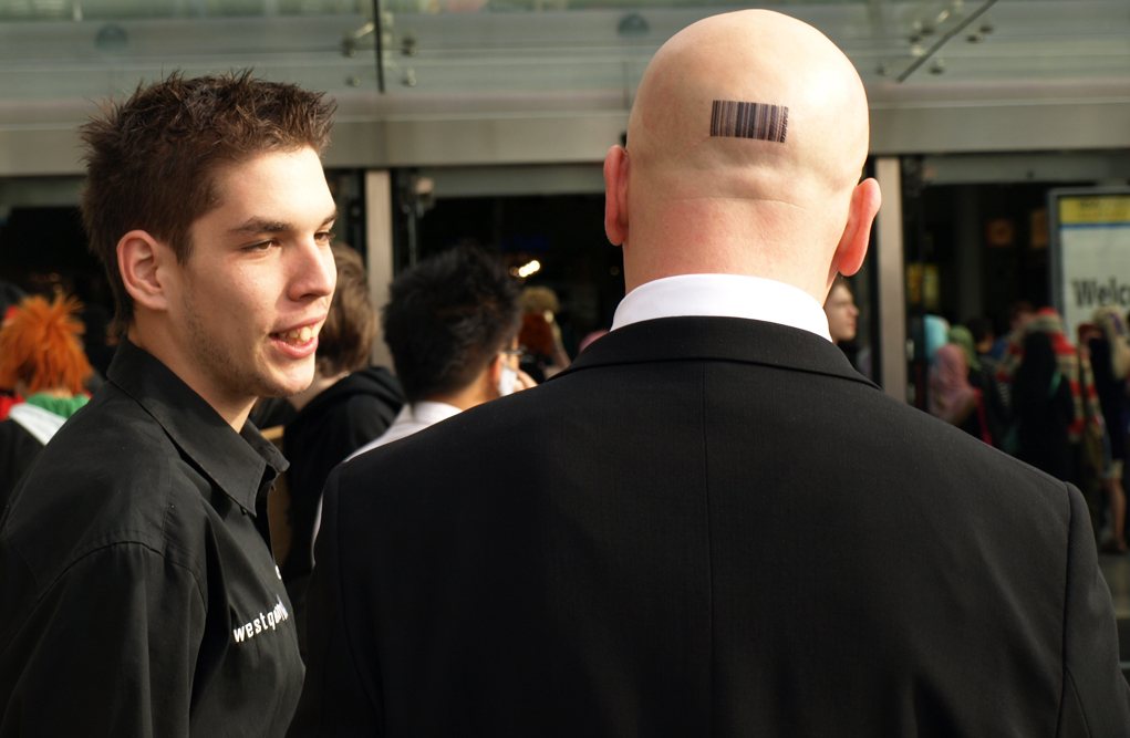 Cosplayer dressed as Agent 47 in a black suit and red tie at London MCM Expo 2008