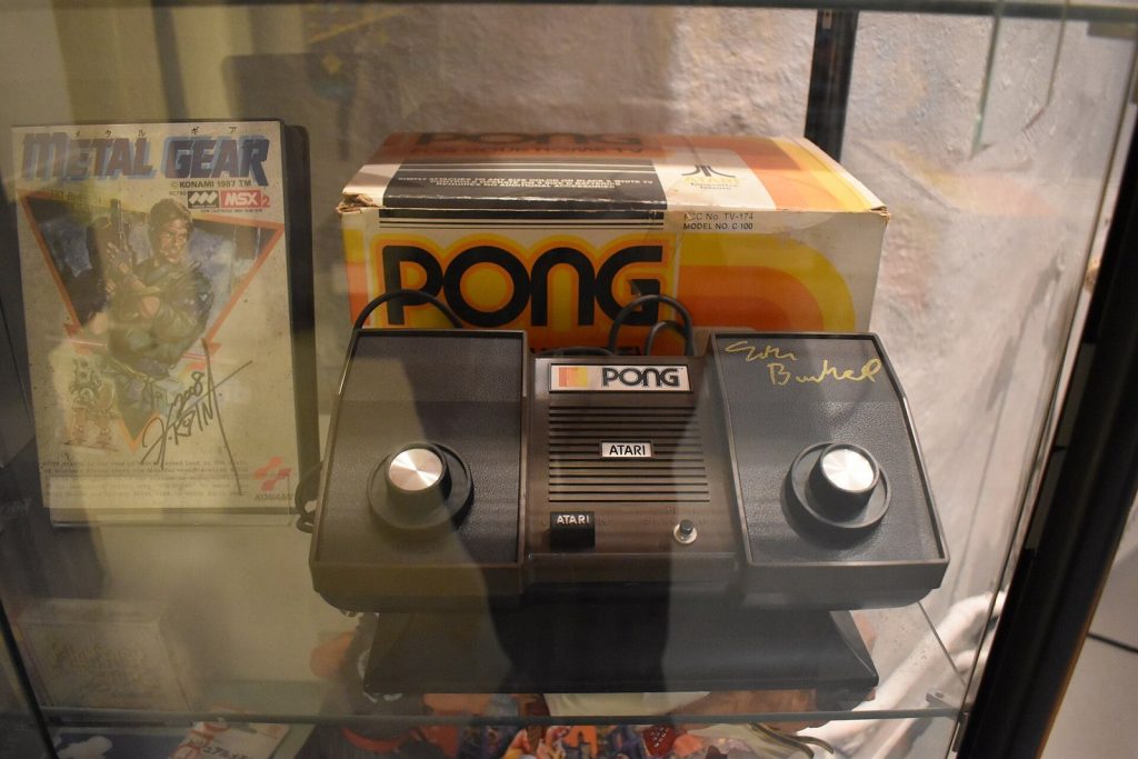 Metal Gear on an MSX2 computer displayed next to an Atari Pong console in a museum