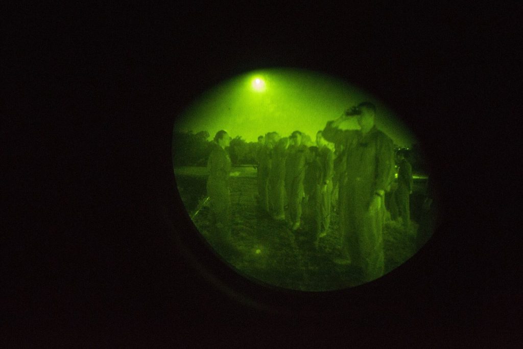 Close view of military night vision goggles with green and white phosphor tubes